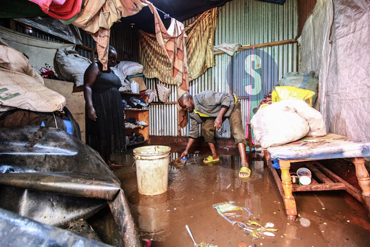 A man clears water from a rental in Kangemi following a heavy downpour in Nairobi.