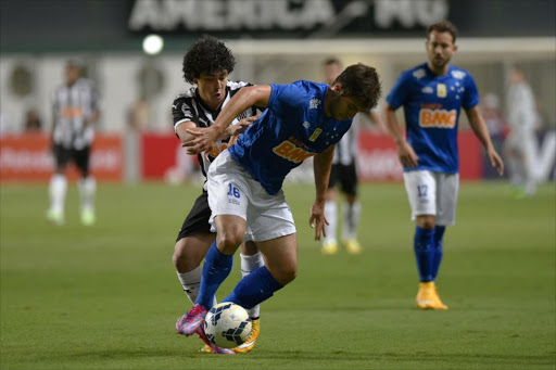 Atletico Mineiro's player Luan vies for the ball with Cruzeiro's player Lucas Silva (R) during their Brazil Cup football match at Independencia Stadium in Belo Horizonte, Brazil on November 12, 2014. Cruzeiro have agreed to sell defensive midfielder Lucas Silva to Real Madrid, the Brazilian champions said on Thursday 23 January 2015.