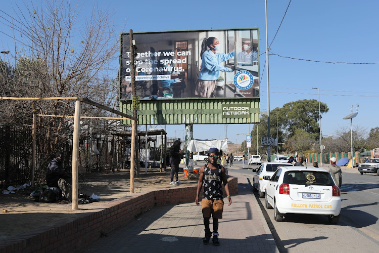 Residents walking through the streets without masks are pictured, 29 June 2021, in Diepsloot, Johannesburg.