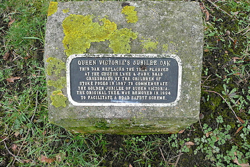 The plaque indicates that an oak tree was planted here in 1887 to commemorate Queen Victoria's Golden Jubilee. This tree is a nearby replacement, following a road safety scheme at the junction in...