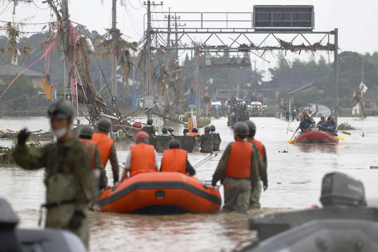 Local residents are rescued by Japanese Self-Defence Force soldiers using a boat at a flooding area caused by a heavy rain in Kuma village, Kumamoto prefecture, southern Japan, on July 5 2020.