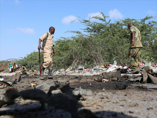 Somali soldiers inspect the scene of a suicide car bomb attack by al Shabaab in Somalia's capital Mogadishu, September 18, 2016. Ongoing conflict due to the presence of al Shabaab is threatening the country's food security /REUTERS