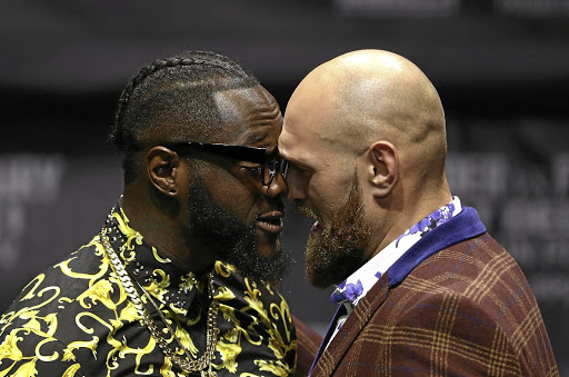Professional boxers Deontay Wilder, left, and Tyson Fury butt heads onstage during a press conference to promote their upcoming fight. /Victor Decolongon/Getty Images
