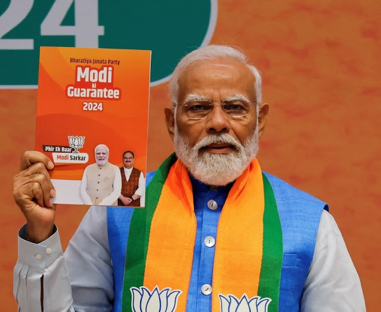 Indian Prime Minister Narendra Modi displays a copy of the ruling Bharatiya Janata Party’s election manifesto for the general election, in New Delhi, India, on Sunday. Picture: REUTERS/ADNAN ABIDI