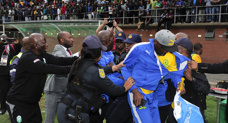 Mamelodi Sundowns coach Pitso Mosimane at the centre of scuffle broke broke out between Mosimane and the head of the security company (not in this picture) that does duty for AmaZulu FC's home matches following an Absa Premiership match at King Zwelithini Stadium in Umlazi, Durban, on Sunday September 16 2018. Sundowns' team manager Peter Ndlovu (wearing a red tie) is seen trying to pull the coach away.