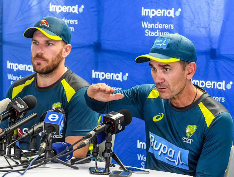 Australia captain Aaron Finch (L) and head coach Justin Langer (R) talk to the media upon their arrival in South Africa.