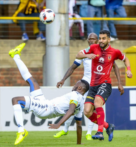 Buhlebuyeza Mkhwanazi of Wits clears the ball under pressure from Amr Alsoulih of Al Ahly during the CAF Champions League Qualifying First Round match between Bidvest Wits and Al Ahly at Bidvest Stadium on March 19, 2017 in Johannesburg, South Africa.