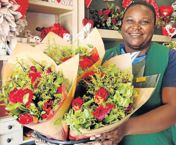 Talent Chikanya, a florist at Flowers PE, prepares bouquets of roses for a customer. Employees at the store, in Newton Park, are working frantically to get all the orders out for Valentine ’s Day on Thursday