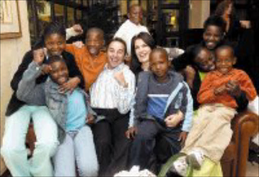 GENEROUS: Former champion of the world Brian Mitchell and his wife Juanita surrounded by the children of Ubuhle Bezwe House in Tembisa this week. © Sowetan.