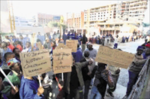 WORKER ANGER: Construction workers who downed tools at the Zone Rosebank Mall in Johannesburg on Wednesday parade around the site yesterday after joining colleagues on strike at other sites around the country. Pic: ELVIS NTOMBELA. 08/07/2009. © Sowetan.