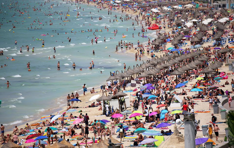 Pre-pandemic tourists sunbathe in El Arenal beach in the island of Mallorca, Spain, August 11, 2018.