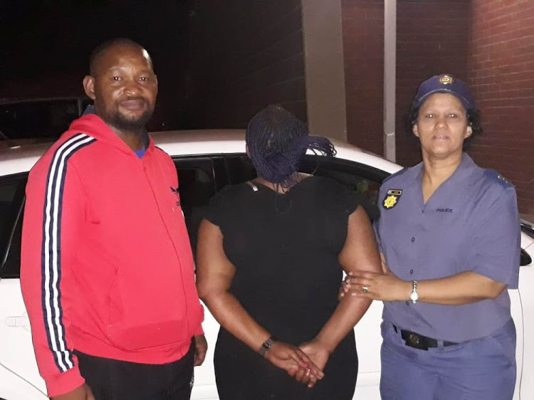 Police with an alleged fraudster who was caught red-handed in Kimberley on Wednesday.