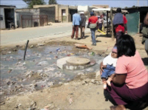 HEALTH HAZARD: This stinking mess is part of the daily life of this mother and child. Pic. Katlego Moeng. 28/08/2008. © Sowetan.