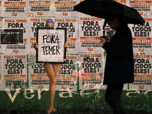People walk past a sign reading "Out Temer" at the end of a protest against Brazil's President Michel Temer in Sao Paulo, Brazil, May 21, 2017. /REUTERS