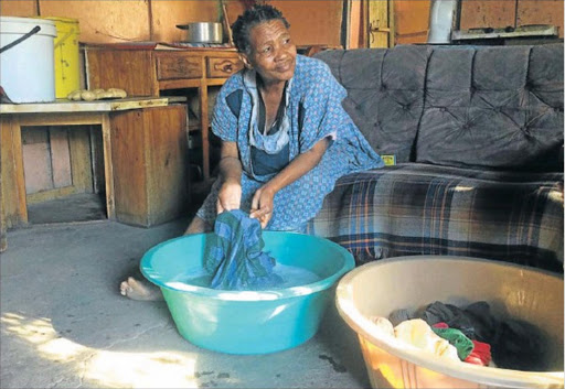 UNSATISFIED: Nozuko Magabeni, 68, doing laundry in her shack said police should speedily investigate the case where her name was removed from the list of RDP beneficiaries