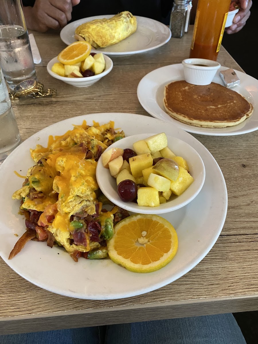 Scramble with eggs, bacon, avocado, tomato, amd cheddar.  Pancake on the side.