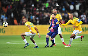 FC Barcelona captain Lionel Messi glides past Tiyani Mabunda (L), Sibusiso Vilakazi (C) and Wayne Arendse of Mamelodi Sundowns during the Nelson Mandela Centenary Cup match at FNB Stadium in Soweto, Johannesburg, on Wednesday May 16 2018.     