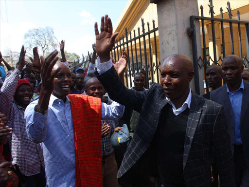 Former Mungiki leader Maina Njenga waves to his supporters at Milimani law court where he sued Jubilee for rejecting his nomination papers, March 22, 2017. /COLLINS KWEYU