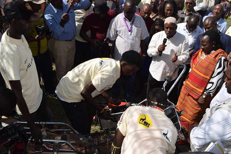 TVET PS Esther Mworia look on as some of the youths repair a motocycle in Isiolo after learning through an initiative Ujuzi Manyattani by NRT