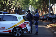 Hawks and members of the SAPS are seen outside the Gupta compound in Saxonwold, Johannesburg on 14 February 2018.