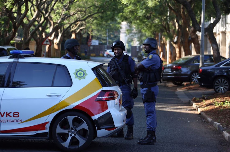 Hawks and members of the SAPS are seen outside the Gupta compound in Saxonwold, Johannesburg on 14 February 2018.