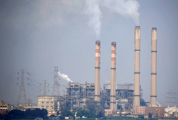Smoke billows from the chimneys of South Cairo Electricity Distribution Company power station, on the side of the River Nile during low tide at Shoubra El-Kheima neighbourhood in Cairo, Egypt, on May 3 2024.