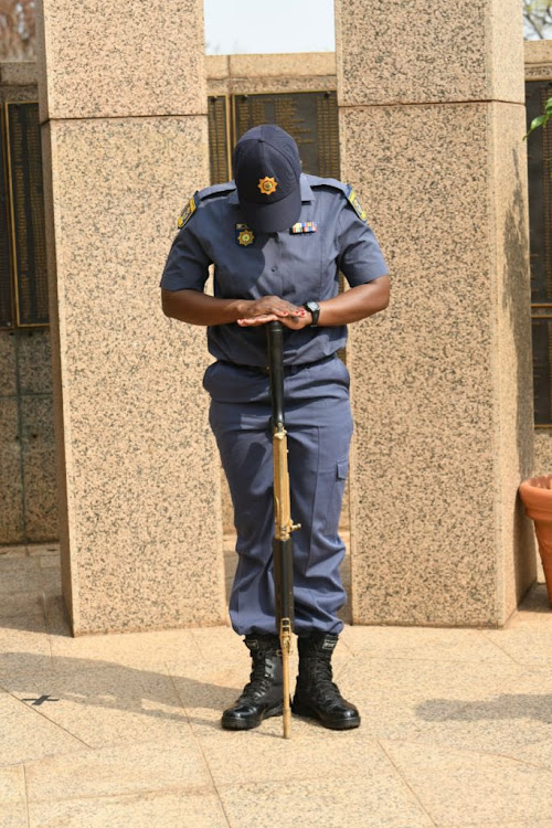 A South African Police Service officer observed a moment of silence on Sunday during the annual memorial service for police officers killed in the line of duty.