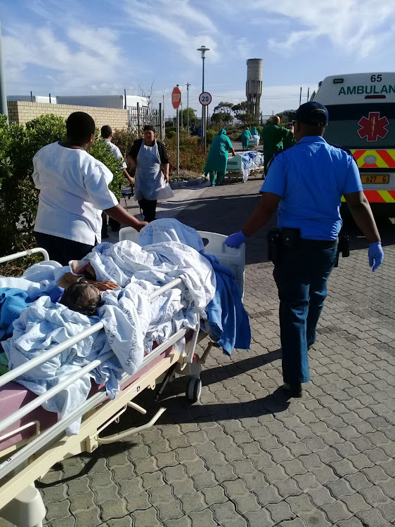 Patients and staff evacuate Mitchells Plan District Hospital in Cape Town early on Saturday after fire broke out in the roof void. Image: City of Cape Town