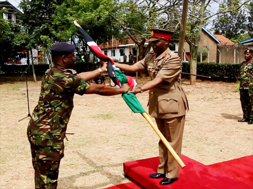 Chef de Mission Brigadier Henry Ofula hands over the national flag to the ACDF P&L Maj. Gen Samuel Nandwa. /COURTESY