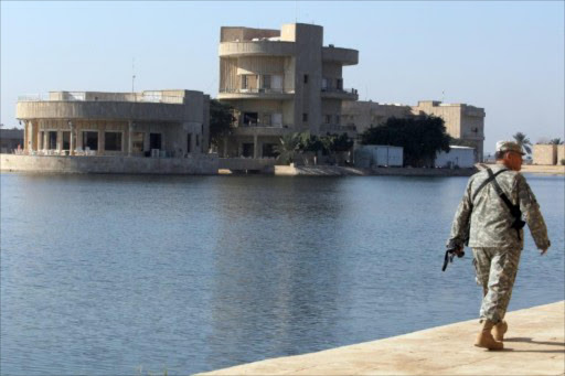 A US soldier walks past the Al-Faw palace on November 7, 2011, formerly owned by executed Iraqi leader Saddam Hussein and located in the Camp Victory complex in Baghdad.