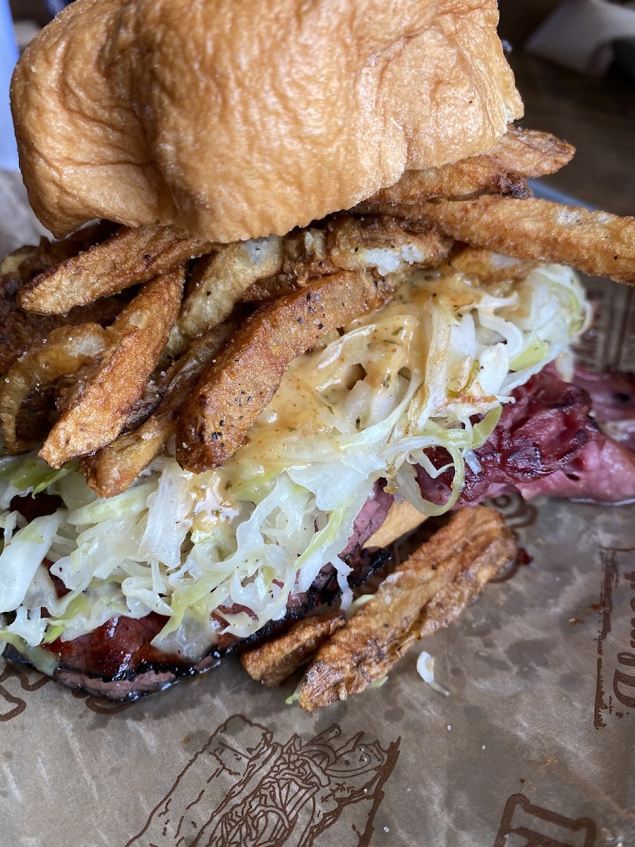 Reuben on Gluten Free Bun stacked wifh fries, coleslaw, and mayo