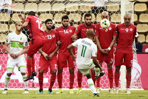 Tunisia's players prepare to block a free kick by Algeria's midfielder Yacine Brahimi during the 2017 Africa Cup of Nations group B football match between Algeria and Tunisia in Franceville on January 19, 2017. KHALED DESOUKI / AFP