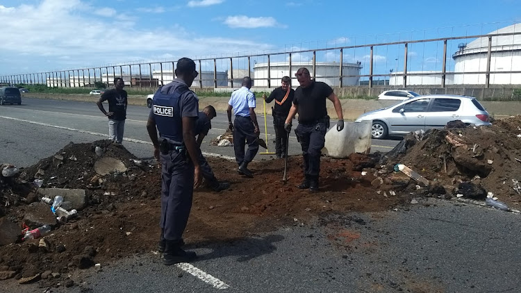 Municipal workers clean up debris and sand left by striking municipal workers on a freeway near Isipingo, south of Durban.