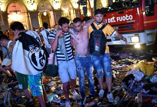 Football Soccer - Juventus v Real Madrid - UEFA Champions League Final - San Carlo Square, Turin, Italy - June 3, 2017 A Juventus' fan is helped to walk as the fans gathered in San Carlo Square run away following panic created by the explosion of firecrackers as they was watching the match on a giant screen.