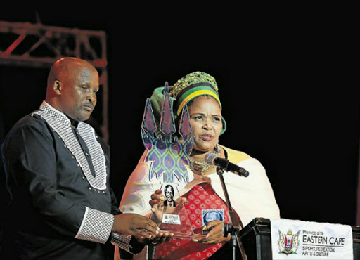 JOURNALISM GONG: The Daily Dispatch’s Lulamile Feni receives an award from department of sport, recreation, arts and culture MEC Pemmy Majodina at the Eastern Cape Cultural Awards on Saturday evening Picture: SINO MAJANGAZA