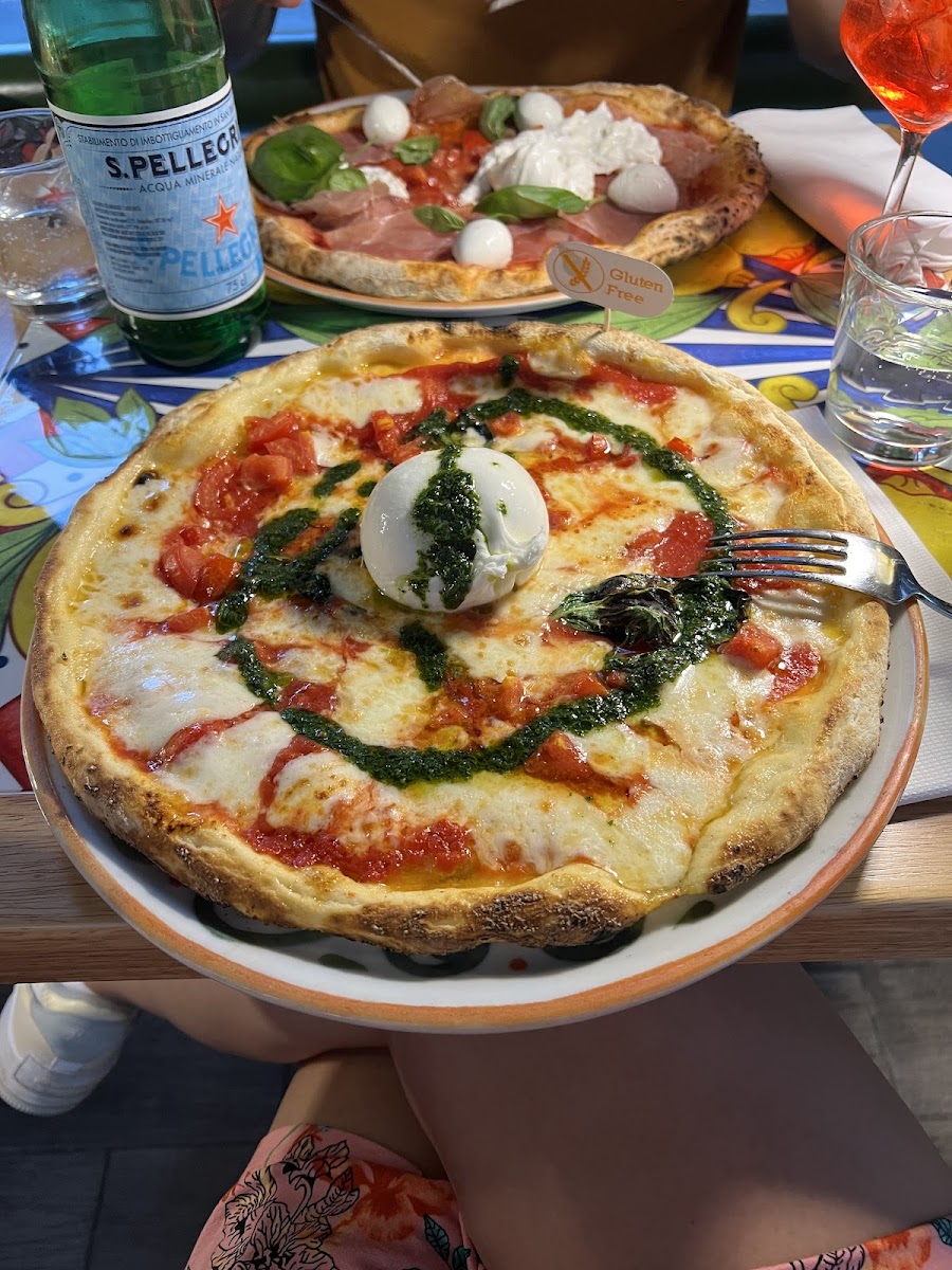 Gluten free pizza with burrata pesto mozerella and tomatoes