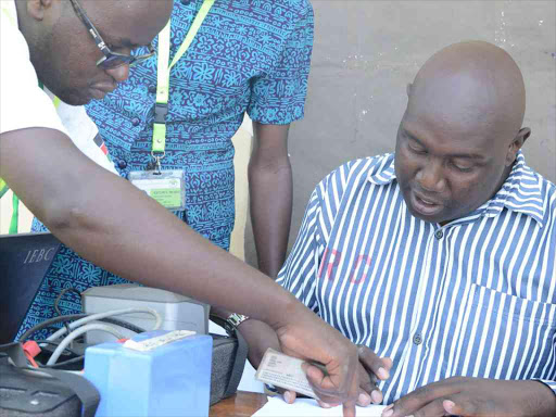 IEBC officers help police imposterJoshua Waiganjo change his polling station at Naivasha GK Prison, February 21, 2017. /GEORGE MURAGE