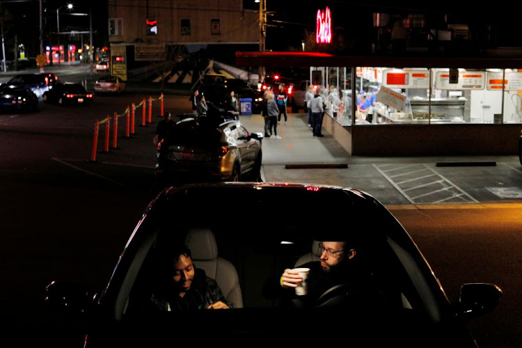 People eat dinner in their car at Dick’s Drive-In as restaurants and bars are limited to take out and delivery service only amid the coronavirus outbreak in Seattle, Washington, US, on March 17 2020.