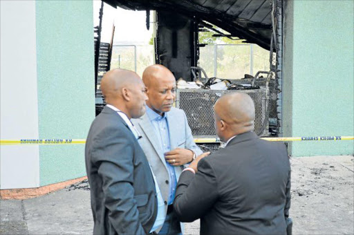 SEARCHING FOR CLUES: Premier Phumulo Masualle, centre, seen here with his advisor Sithembele Mase and spokesman Sonwabo Mbananga inspecting the damage caused by the fire that engulfed a storage room in his office on Friday. Some of the documents that were burnt include those probing irregular expenditure committed by the provincial government departments since 2010 Picture: RANDALL ROSSKRUGE