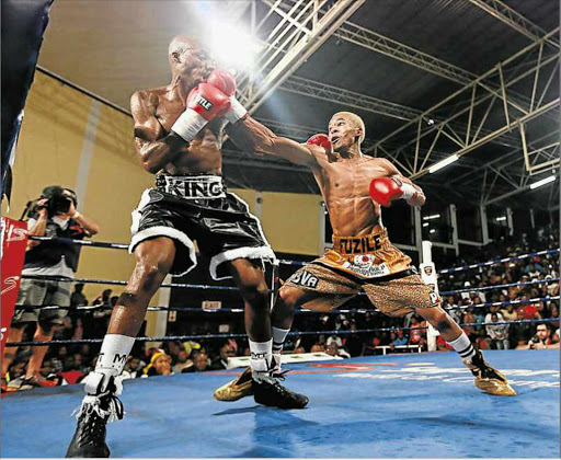 MAJOR UPSET: Young Azinga Fuzile, right, leads with a right punch to the face of Macbute Sinyabi at the Orient Theatre on Friday Picture: MARK ANDREWS