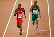Justin Gatlin of the U.S. (L) and Henricho Bruintjies of South Africa compete in the men's 100 metres heats during the 15th IAAF World Championships at the National Stadium in Beijing, China August 22, 2015.
