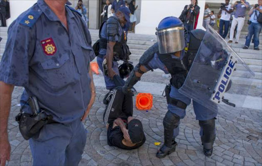 South African students protest outside the parliament precinct before forcing their way through the gates of parliament on October 21, 2015 in Cape Town. TimesLIVE