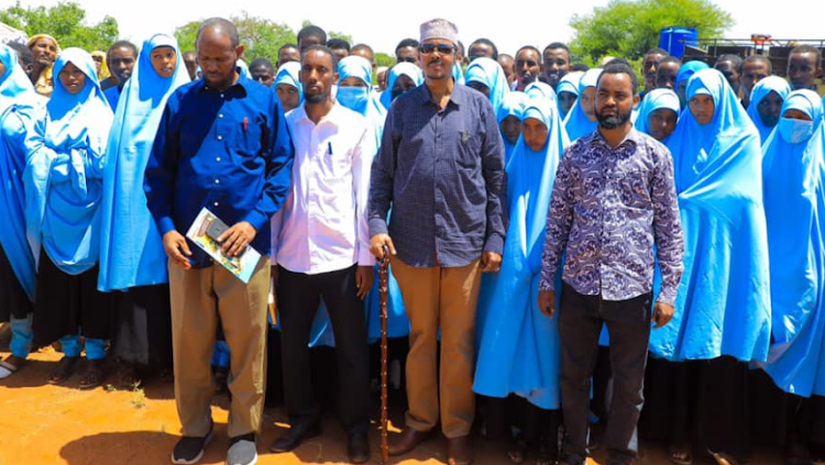 Eldas MP Adan Keynan [C] poses for a group photo with school heads and students from his constituency.
