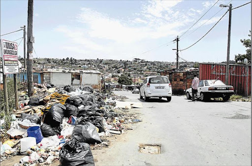 STINKING: Duncan Village residents complain their rubbish has not been collected since November, creating heaps in the streets that obstruct traffic Picture: SIBONGILE NGALWA
