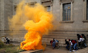 OCTOBER 4 , 2016. SMOKED OUT: Students duck teargas fired by police to disperse those who gathered outside the Great Hall. Picture: Alon Skuy ©The Times.