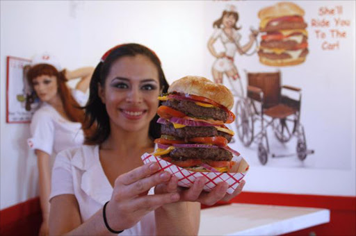 Heart Attack Grill waitress shows off the 'Quadruple Bypass Burger'