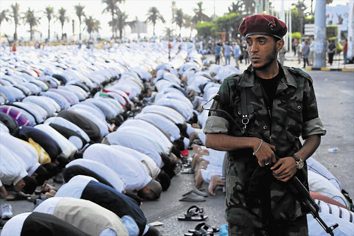 A soldier monitors Eid prayers in Green Square in Tripoli, Libya