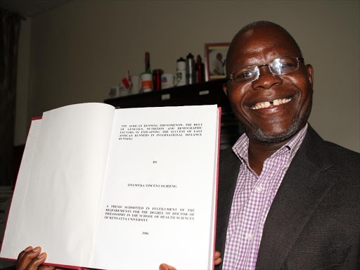 Professor Vincent Onyiera displays his PHD with summary of his research on what makes Kenya athletes great.PHOTO/PHILIP KAMAKYA