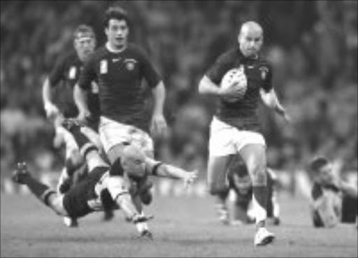 OUTPACE: France's Frederic Michalak, right, gets past the dive of New Zealand's Brendon Leonard during thier quaterfinal match at the Millennium Stadium in Cardiff, Wales on Saturday. Pic. Tom Hevezi. 06/10/2007. © AP