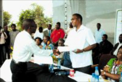 WORRYING RITUALS: Limpopo Premier Sello Moloto, right, receives documents at the rally at Phalama sports ground in Thohoyandou on Saturday. The papers were signed by members of the community, who are pledging to fight the high incidence of ritual killings. © Sowetan.